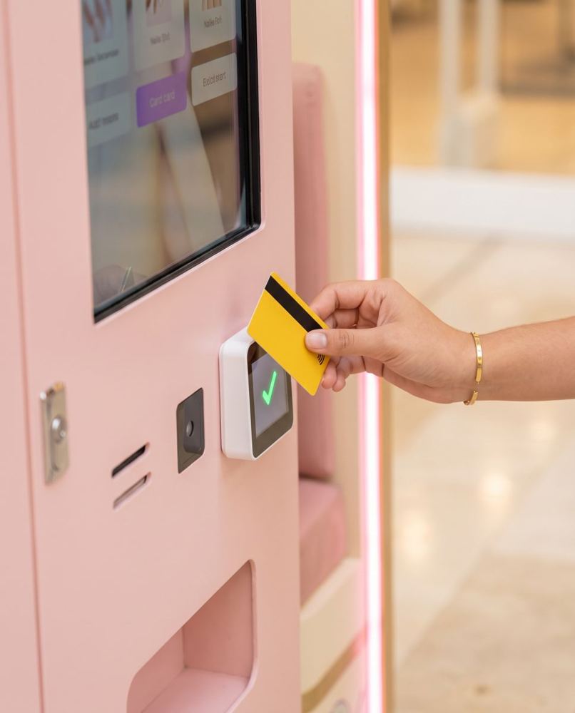 Tarjeta acercándose al lector de pago de la cabina